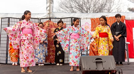 Group of people in traditional Japanese dress performing on stage