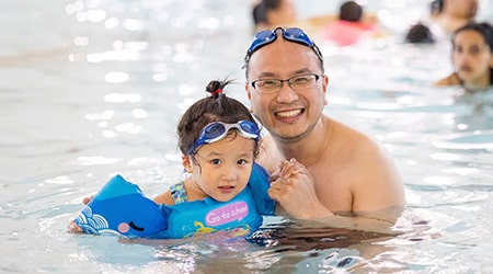 Little girl and her father swimming in pool