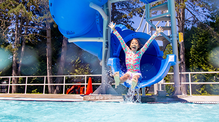 Child sliding down a blue water slide