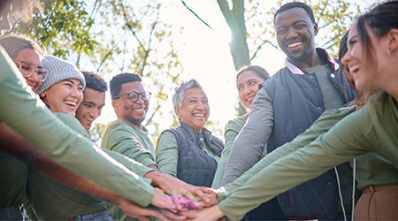 Group of people in a circle with hands in the center