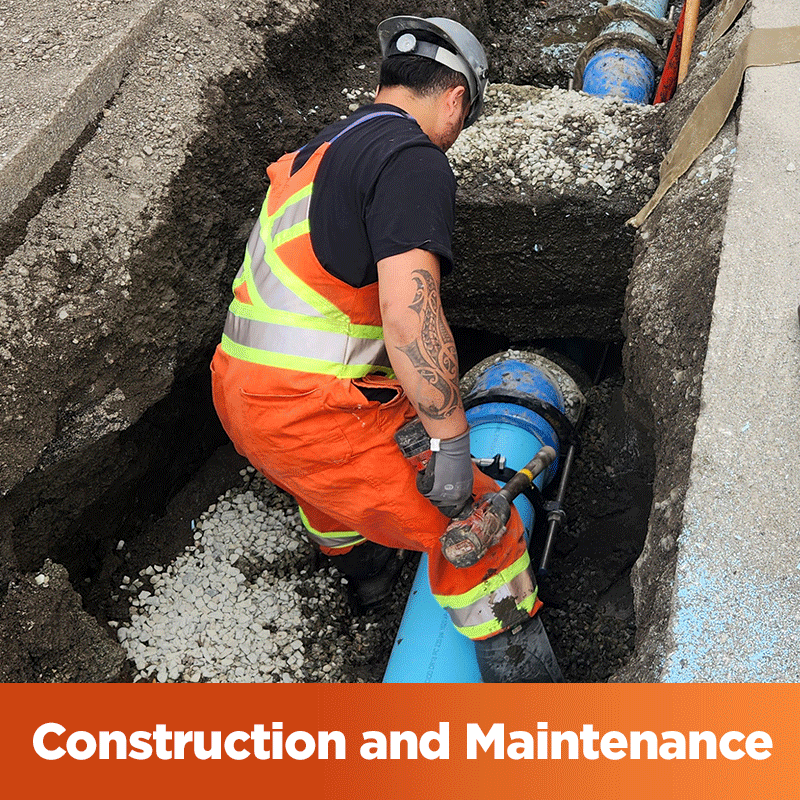 Construction & Maintenance - City worker repairing a watermain in an excavated trench