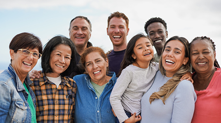 Diverse group of people of different ages smiling together outdoors