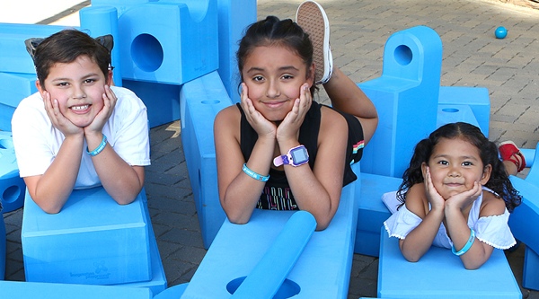 Children playing on big blue blocks