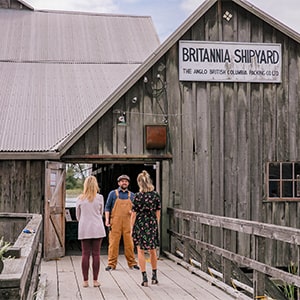 Three people conversing at the entrance of Britannia Shipyard