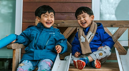 Three preschooler sitting together in a playground