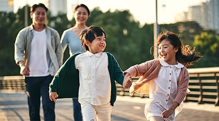 Young family of four walking in a park