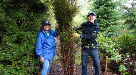 Image of 2 people holding trees at the Richmond Nature Park