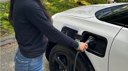 A person getting ready to use the EV charger to charge their vehicle