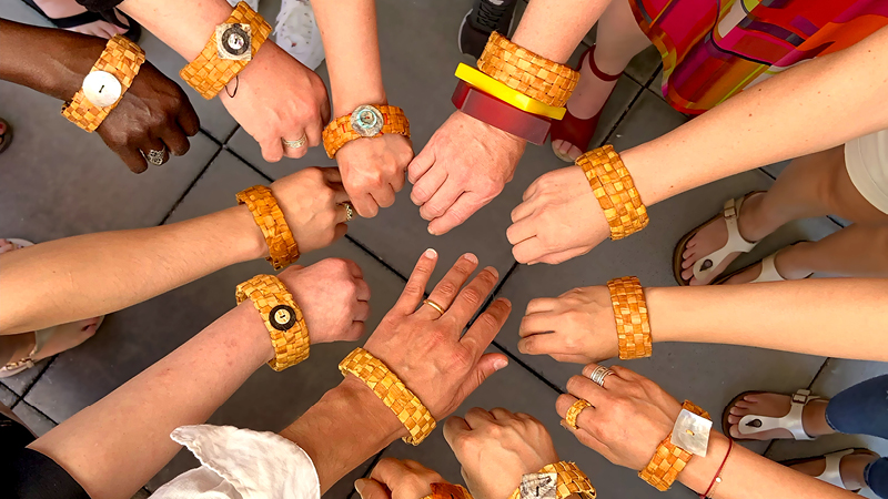 Hands with woven bracelets in a circle