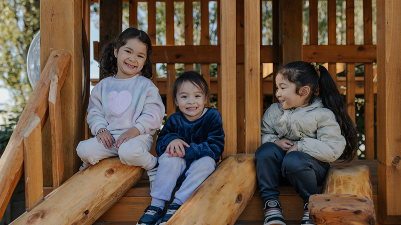 Three children sitting in a treehouse