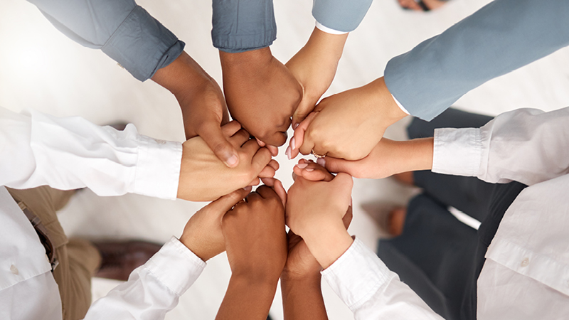 Hands of many people held together in a circle