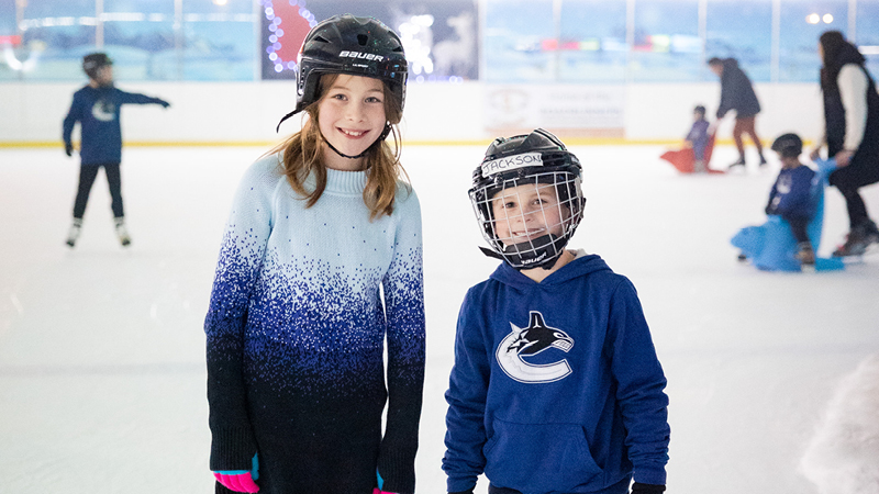 Two children skating at the arena