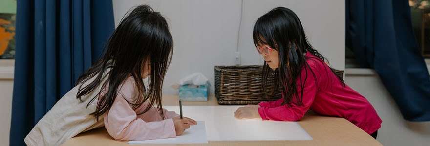 Two little girls drawing at a table