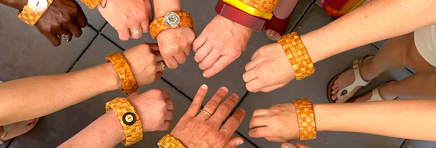 Many hands wearing woven bracelets