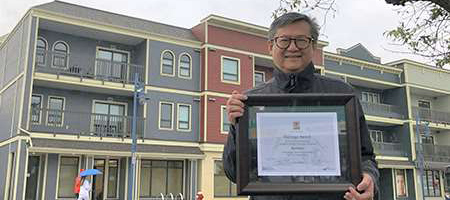 A photo of Ken Chow in Steveston with his Heritage Award