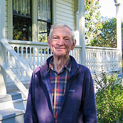A man standing in front of a heritage home