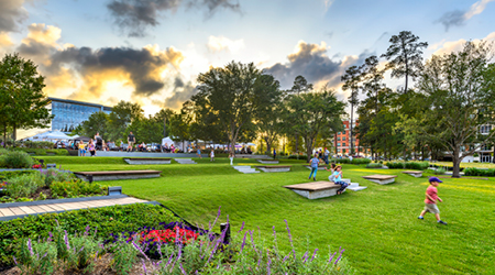 Concept image: people enjoying a vibrant urban park with lush green lawns, trees and seating areas