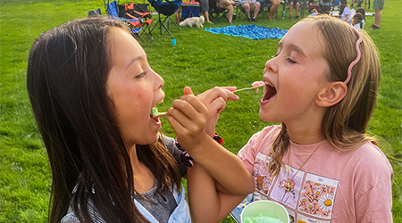Two girls eating ice cream on a sunny day
