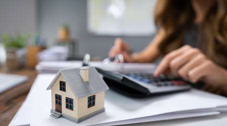 View of a person paying their property tax online with a model house in focus