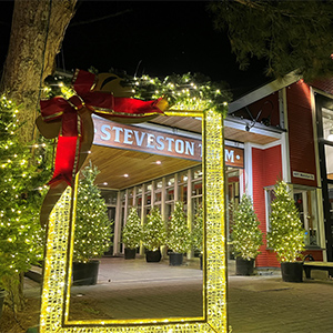 View of the exterior of Steveston Tram building decked out with holiday lights.