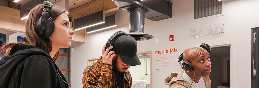 Three young people working together in a media lab